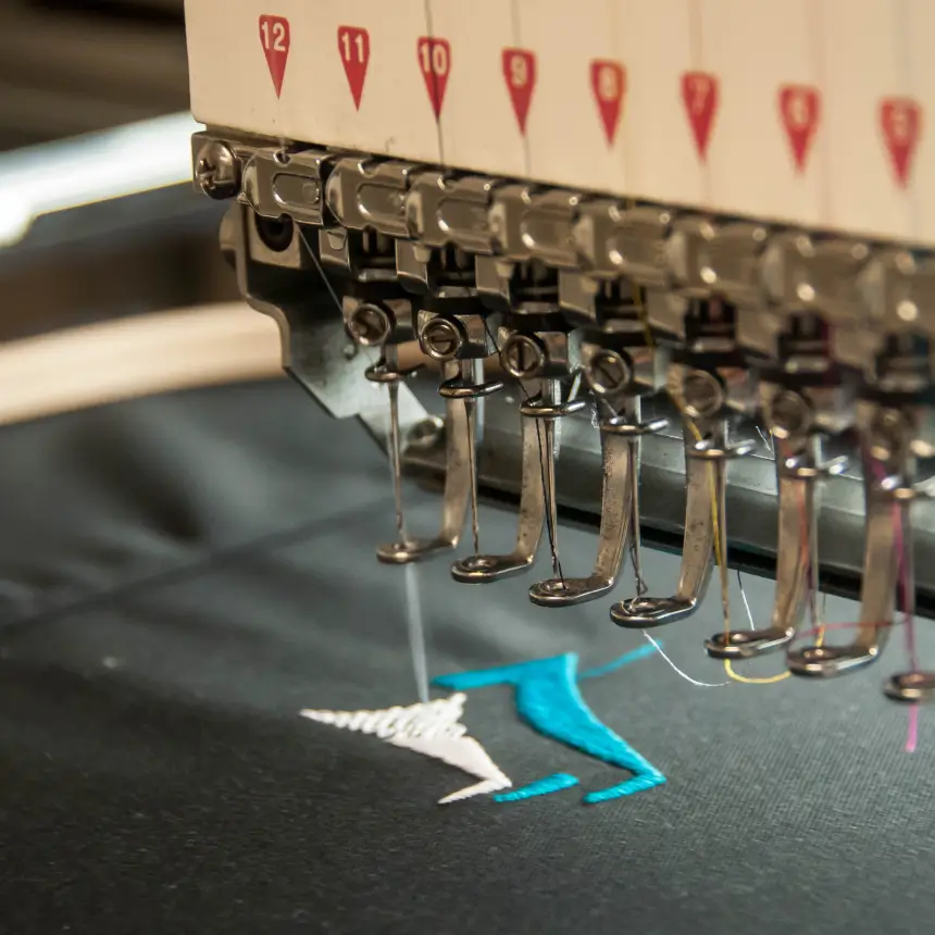 A machine is being embroidered with blue thread.