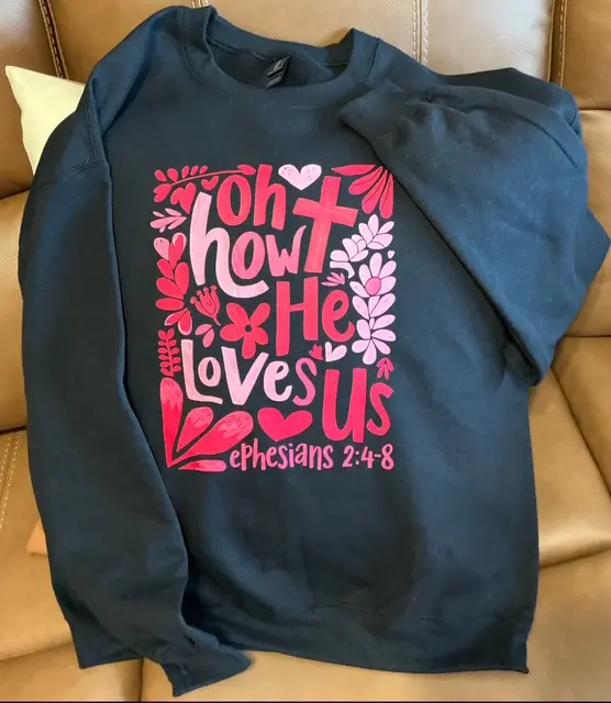 Sweatshirt with religious text and floral design.
