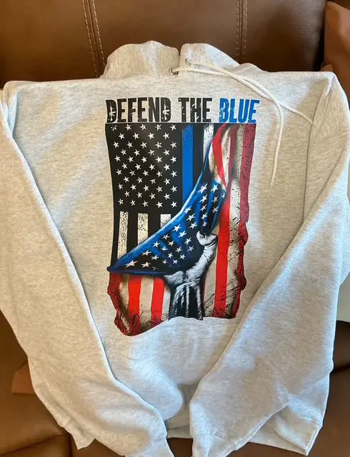 A white hoodie with an american flag and blue boots on it.