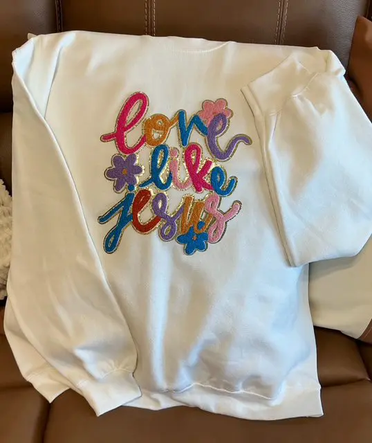 A white shirt that has some colorful writing on it