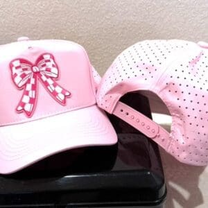 A pink hat sitting on top of a black box.