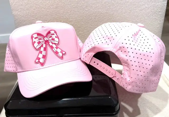 A pink hat sitting on top of a black box.