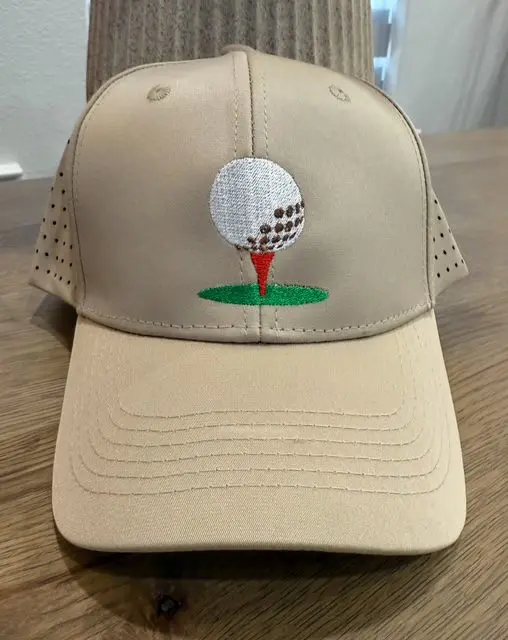 A tan hat with a golf ball on it.