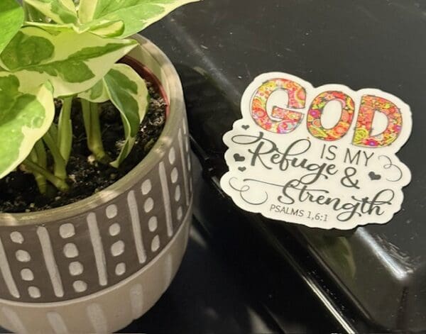 A plant and sticker with the words god is my refuge and strength