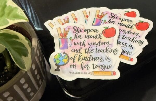 A close up of stickers with the words " she opens her mouth, i will wisdom and the teaching of kindness is on her tongue ".