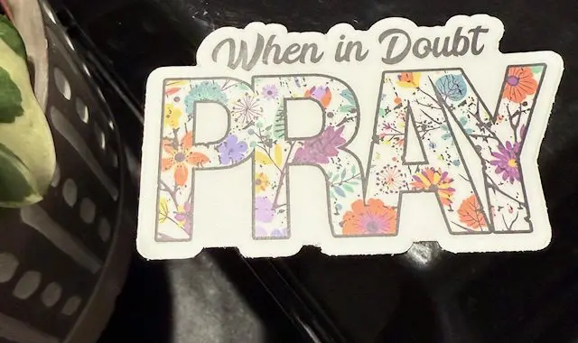 A sticker that says " when in doubt, pray ".