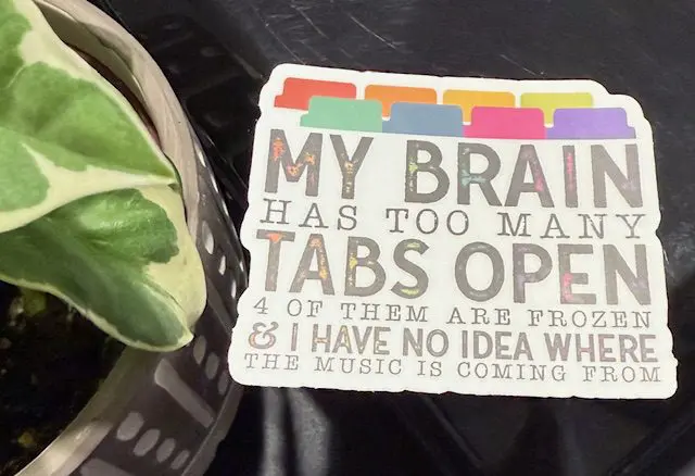 A close up of a sticker with the words " my brain has too many tabs open ".