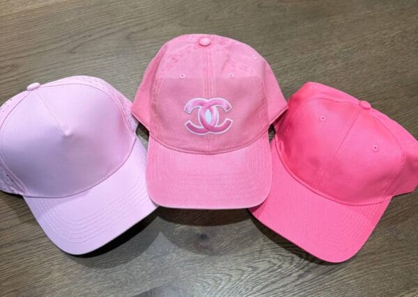 Three pink hats are sitting on a table.