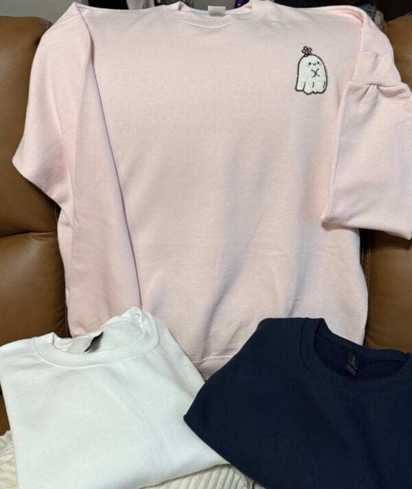 A white shirt sitting on top of a brown couch.