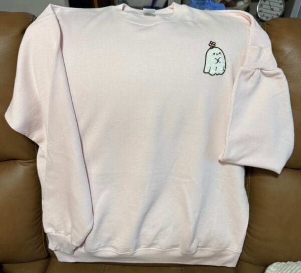 A white sweatshirt with an image of a bottle on it.