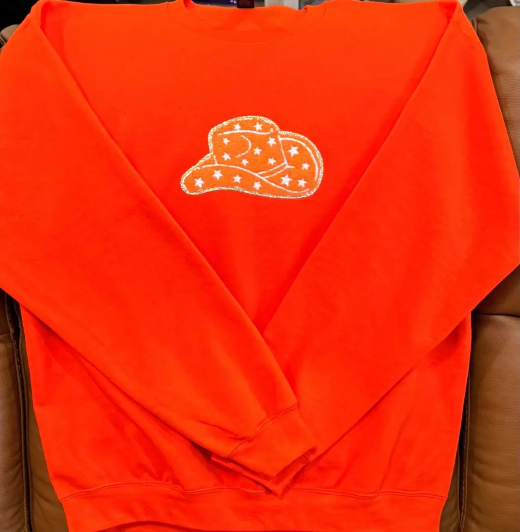 A red sweatshirt with an orange hat on it.