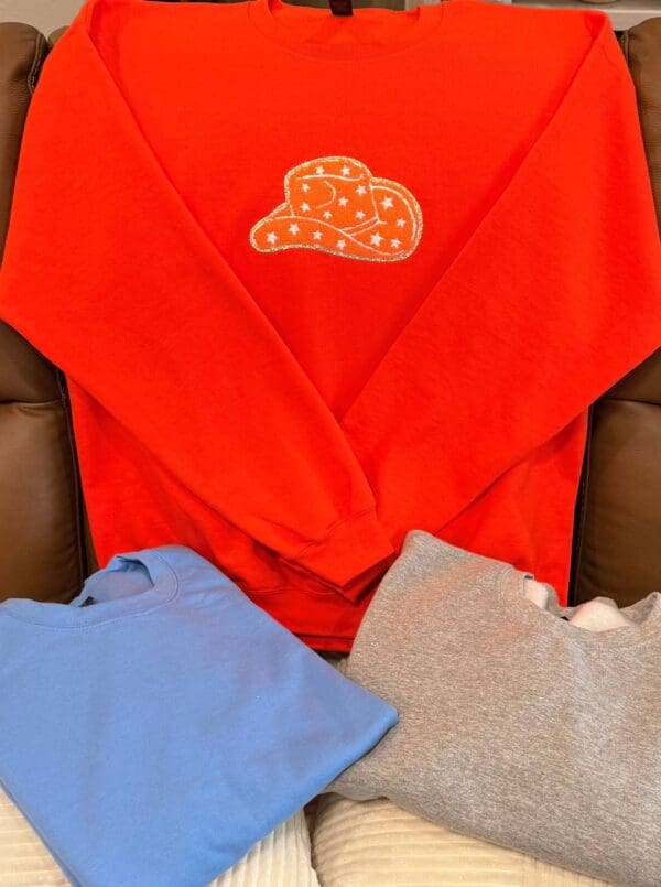 A red shirt sitting on top of a brown couch.