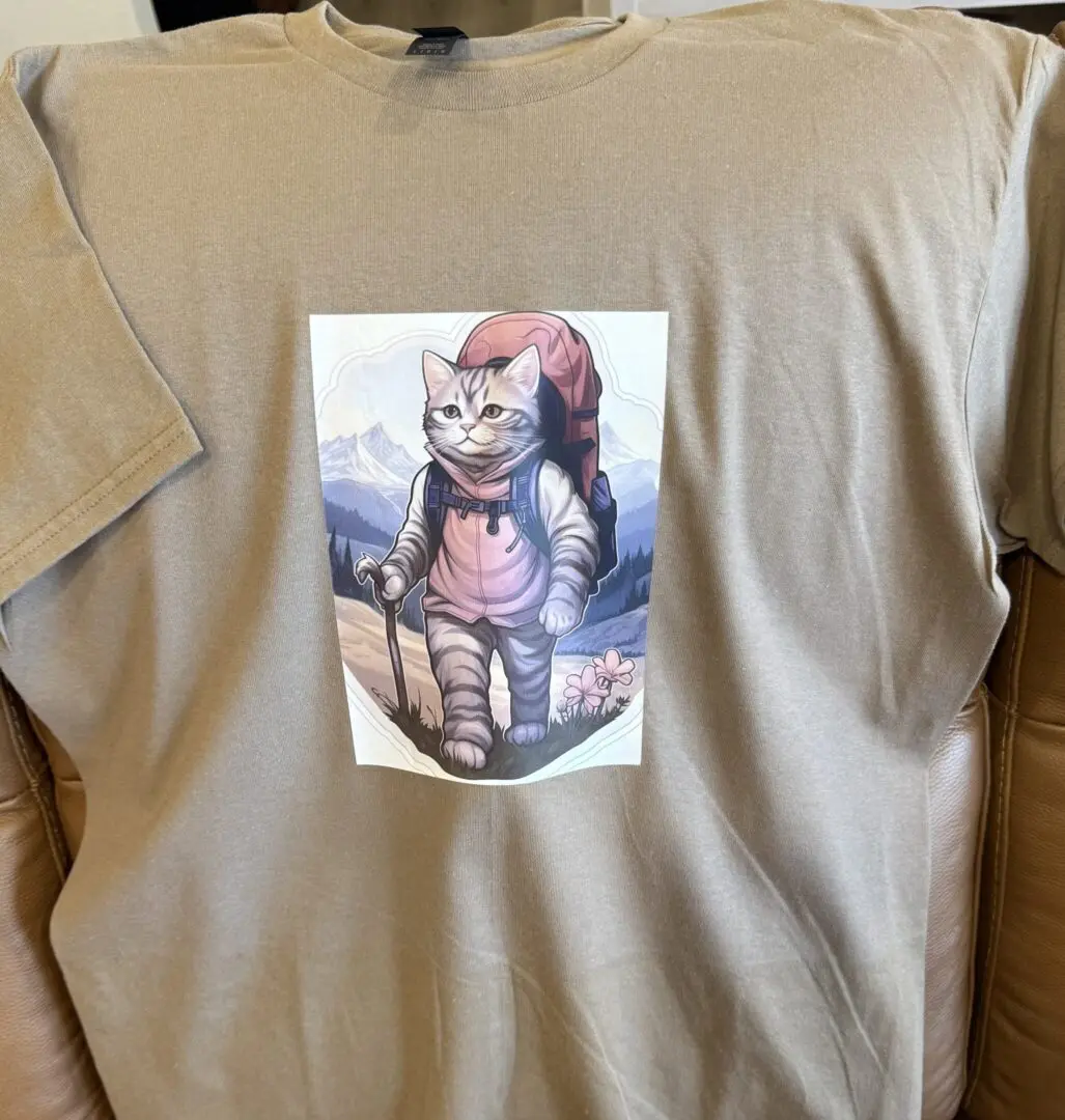 A cat is sitting on top of a t shirt.