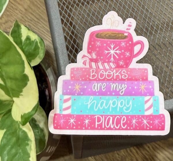 A pink and white book stack with a cup of coffee on top.