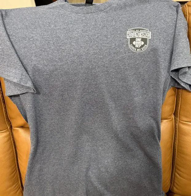 A gray t-shirt with an image of a police badge on it.