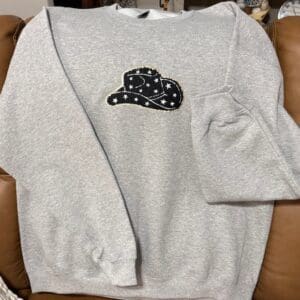 A sweatshirt with a patch of a hat on it.