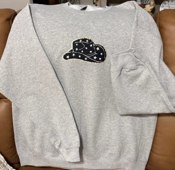 A sweatshirt with a patch of a hat on it.