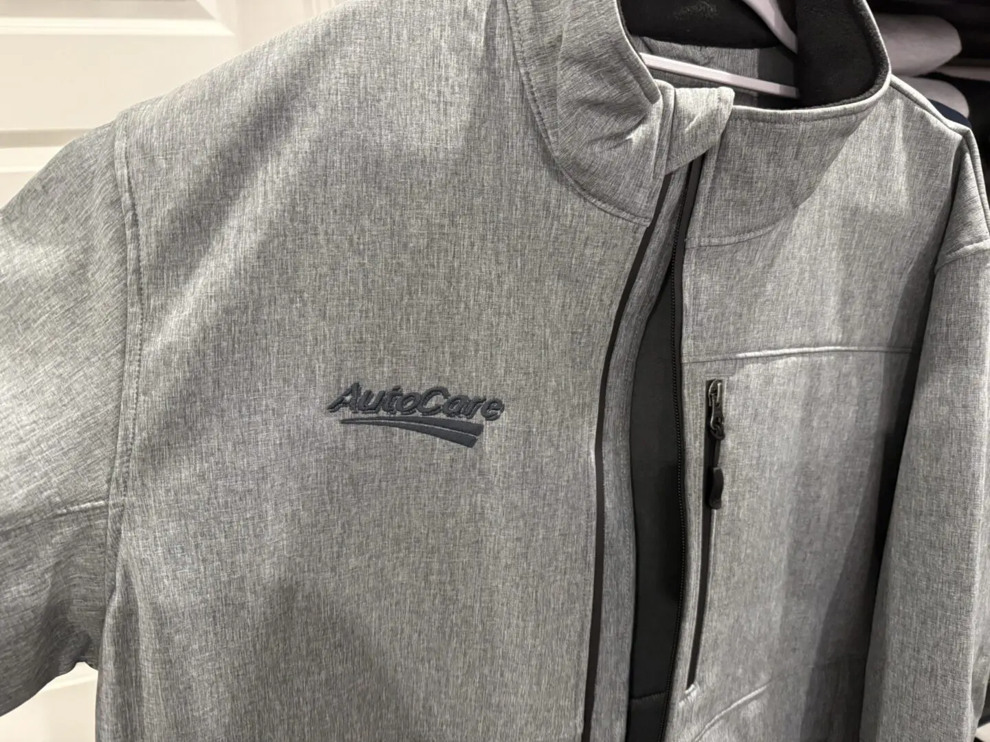 AUTOCARE Gray jacket with "AutoCare" logo.