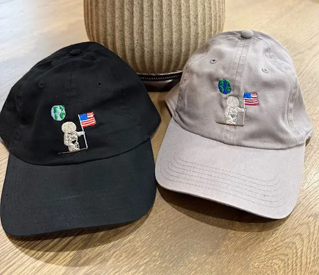 Two caps with astronaut and flag embroidery.