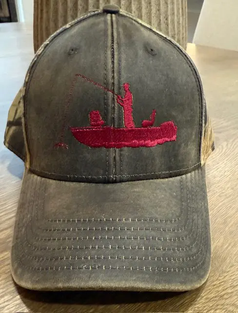 Cap with red embroidered fishing design.