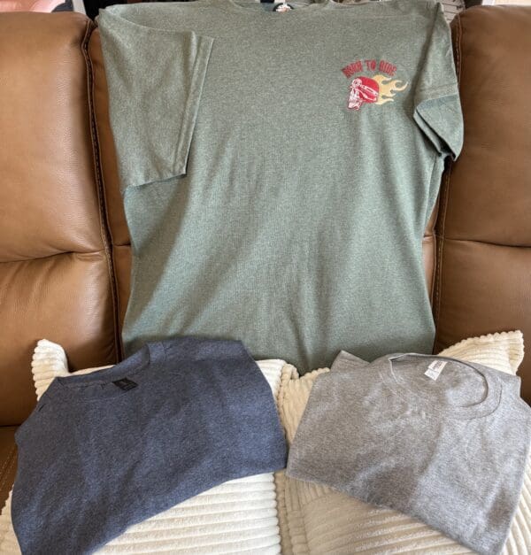 Three T-shirts on a couch.