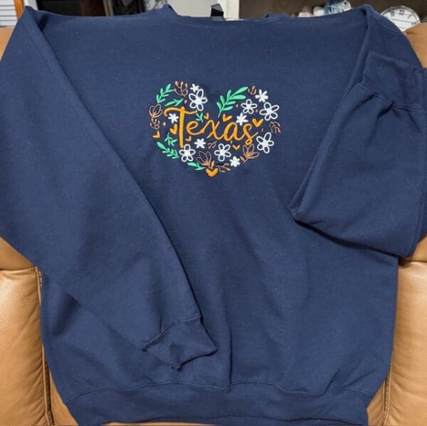 Navy sweatshirt with Texas floral heart design.