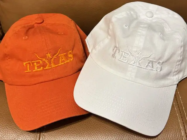 Orange and white Texas hats on couch.