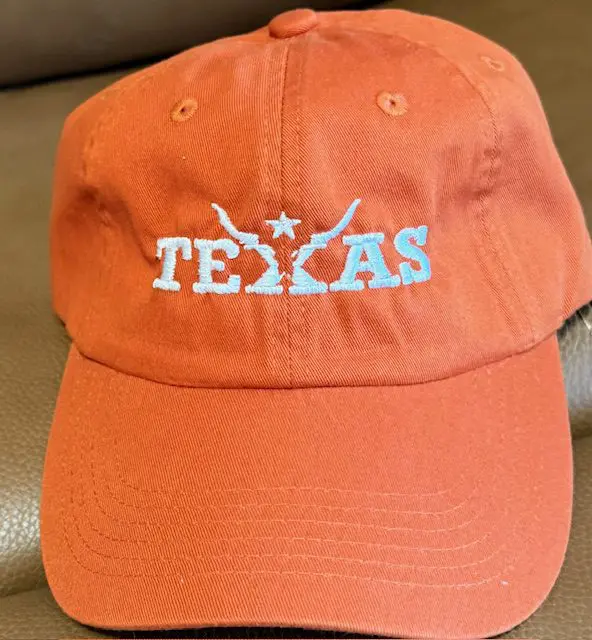 Orange Texas cap with embroidered design.