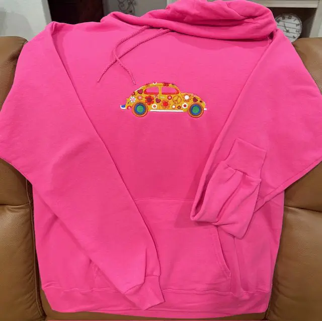 Pink hoodie with colorful car design.