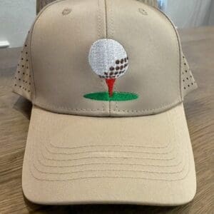Beige cap with golf ball embroidery.