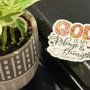 Plant pot with inspirational religious sticker.