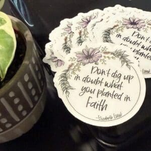 Decorative quote stickers beside a potted plant.