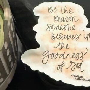 Inspirational quote beside a potted plant.