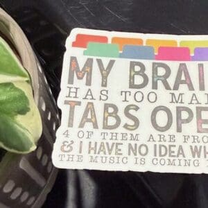 Sign with humorous text beside a plant.