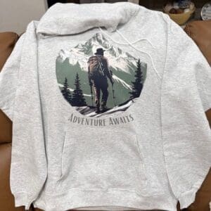 Gray hoodie with mountain adventure graphic.