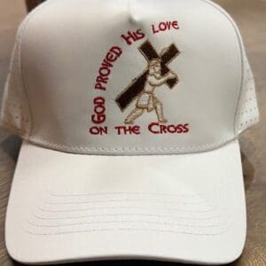 White cap with religious embroidery and text.