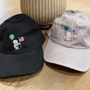 Two caps with astronaut and flag design.