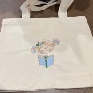 Embroidered tote bag with reading character design.
