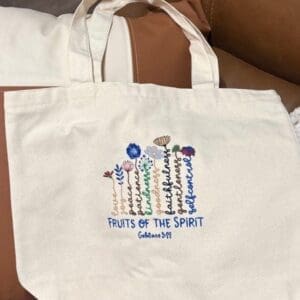 Embroidered tote bag with floral design.