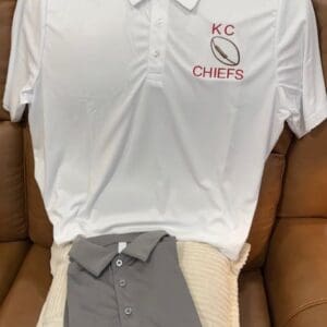 White KC Chiefs polo shirt on chair.