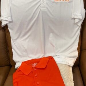 White and orange polo shirts displayed together.