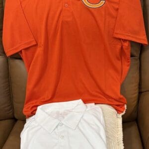 Orange and white polo shirts on chair.