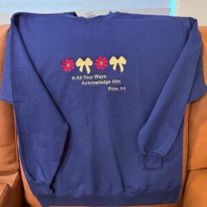 Blue sweatshirt with floral and bow design.