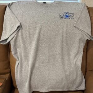 Gray T-shirt with Cowboys logo on couch.