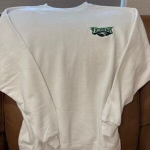 White sweatshirt with Eagles logo on chest.