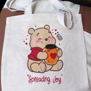 Tote bag with bear and honey design.