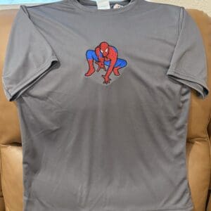 Gray shirt with Spider-Man design on couch.