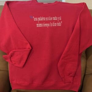 Red sweatshirt with Spanish text design.