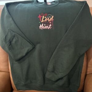 Green sweatshirt with inspirational embroidered text.